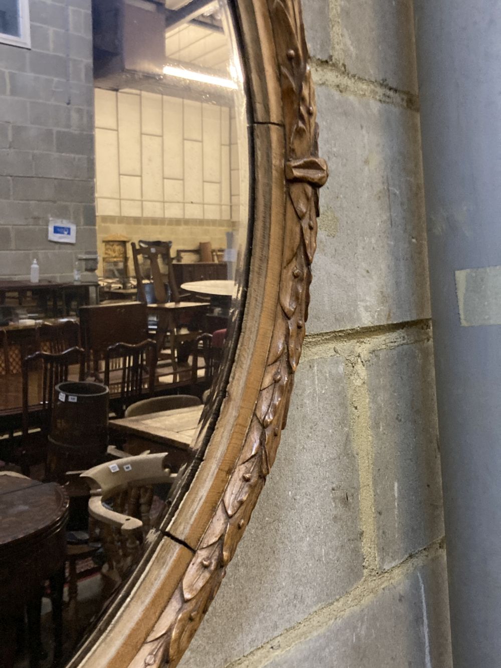 An oval laurel carved mirror, width 64cm height 75cm